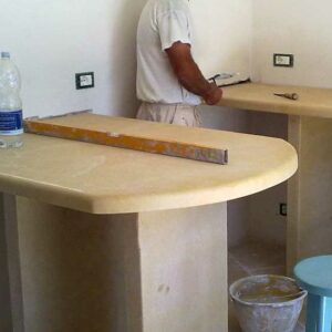 Cucina in muratura moderna con isola in pietra bianca