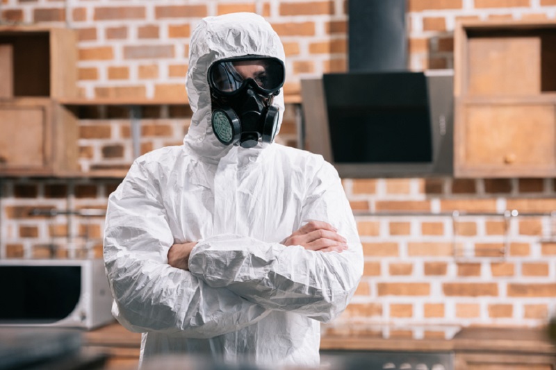 lavoratore con tuta e maschera protettiva su cantiere durante il lock down della pandemia da coronavirus covd-19